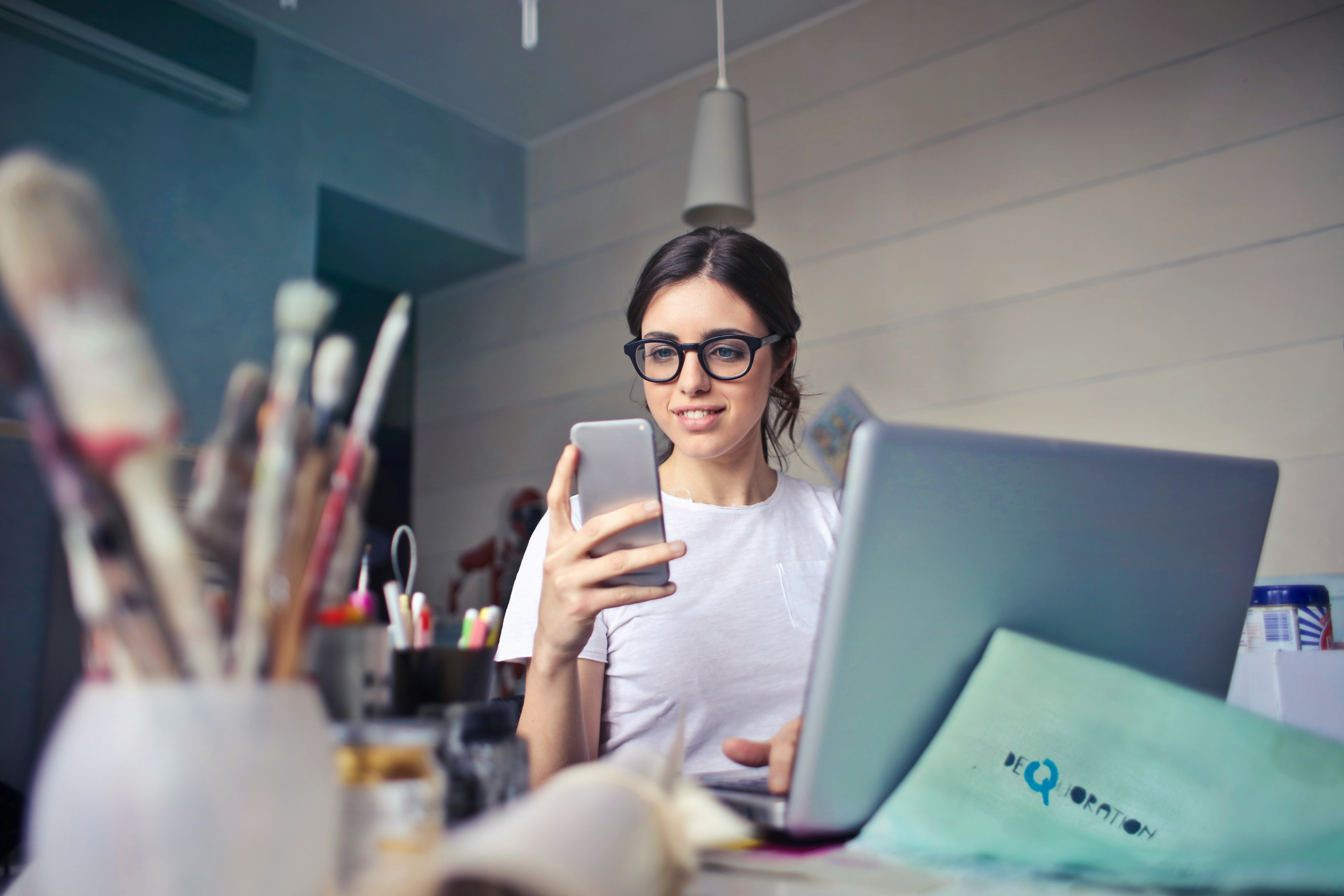 Business professional reviewing sales pipeline data on laptop and phone