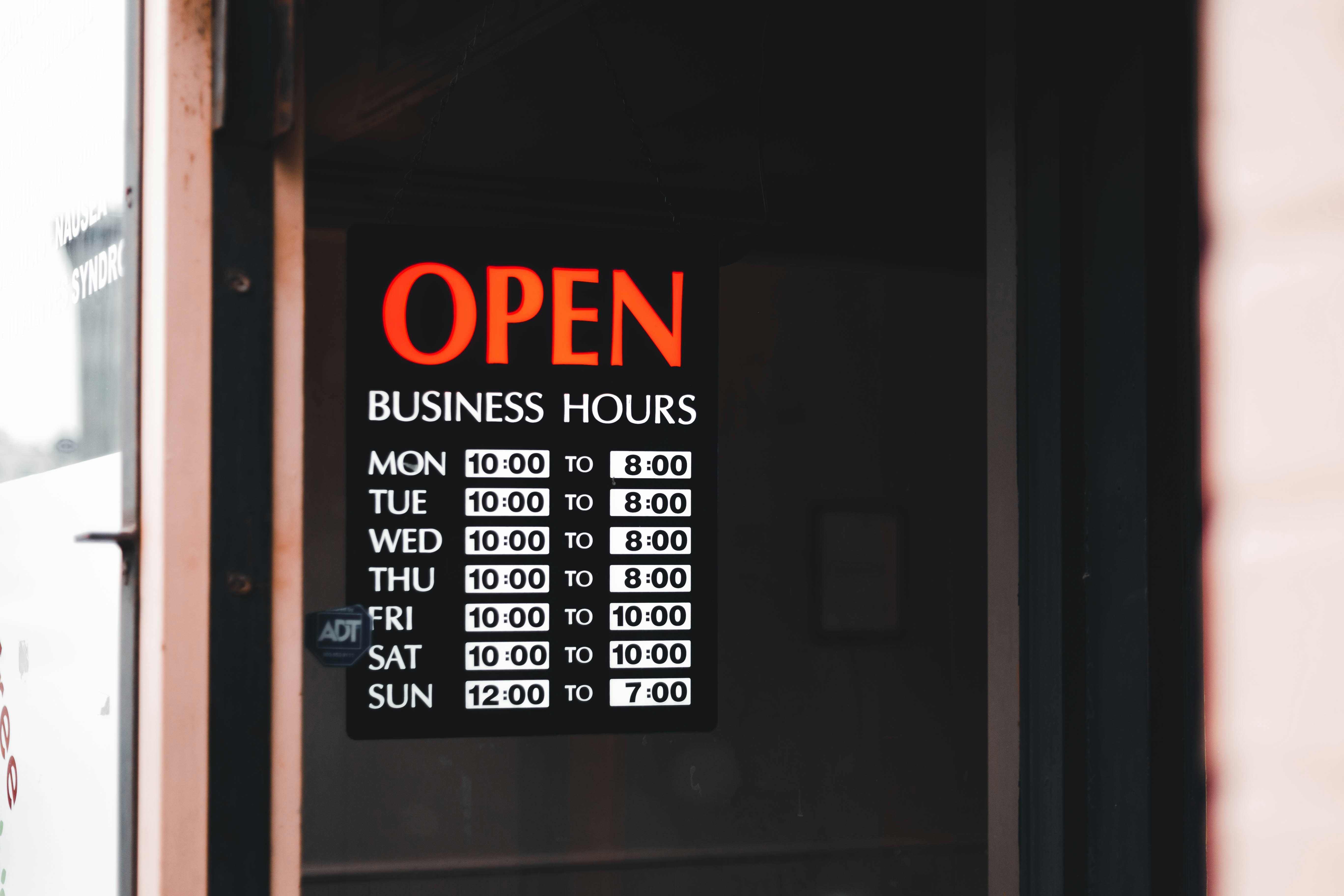 Open sign with business hours in a shop window