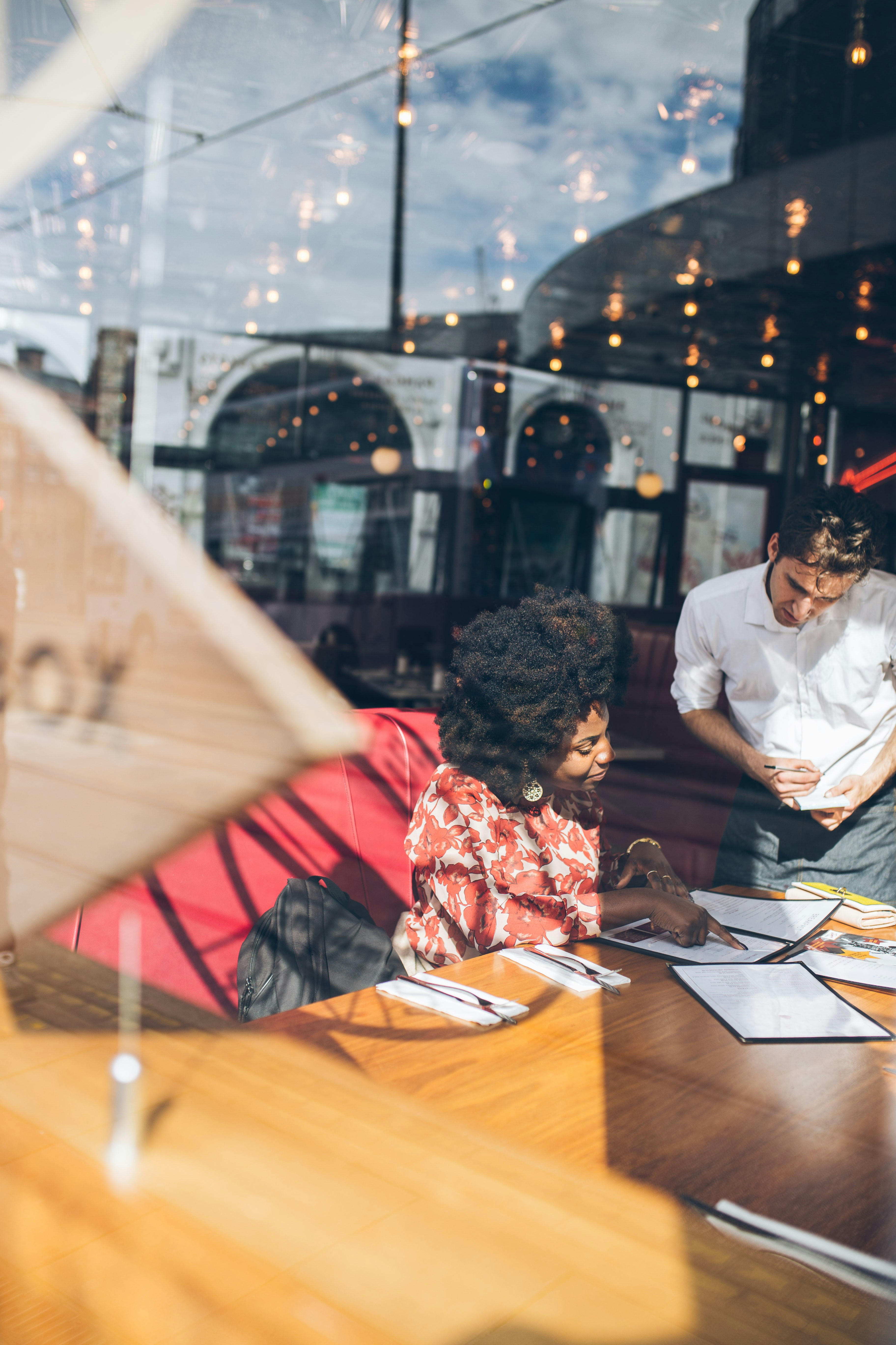 Two business professionals reviewing documents together in a restaurant, making decisions with limited available data