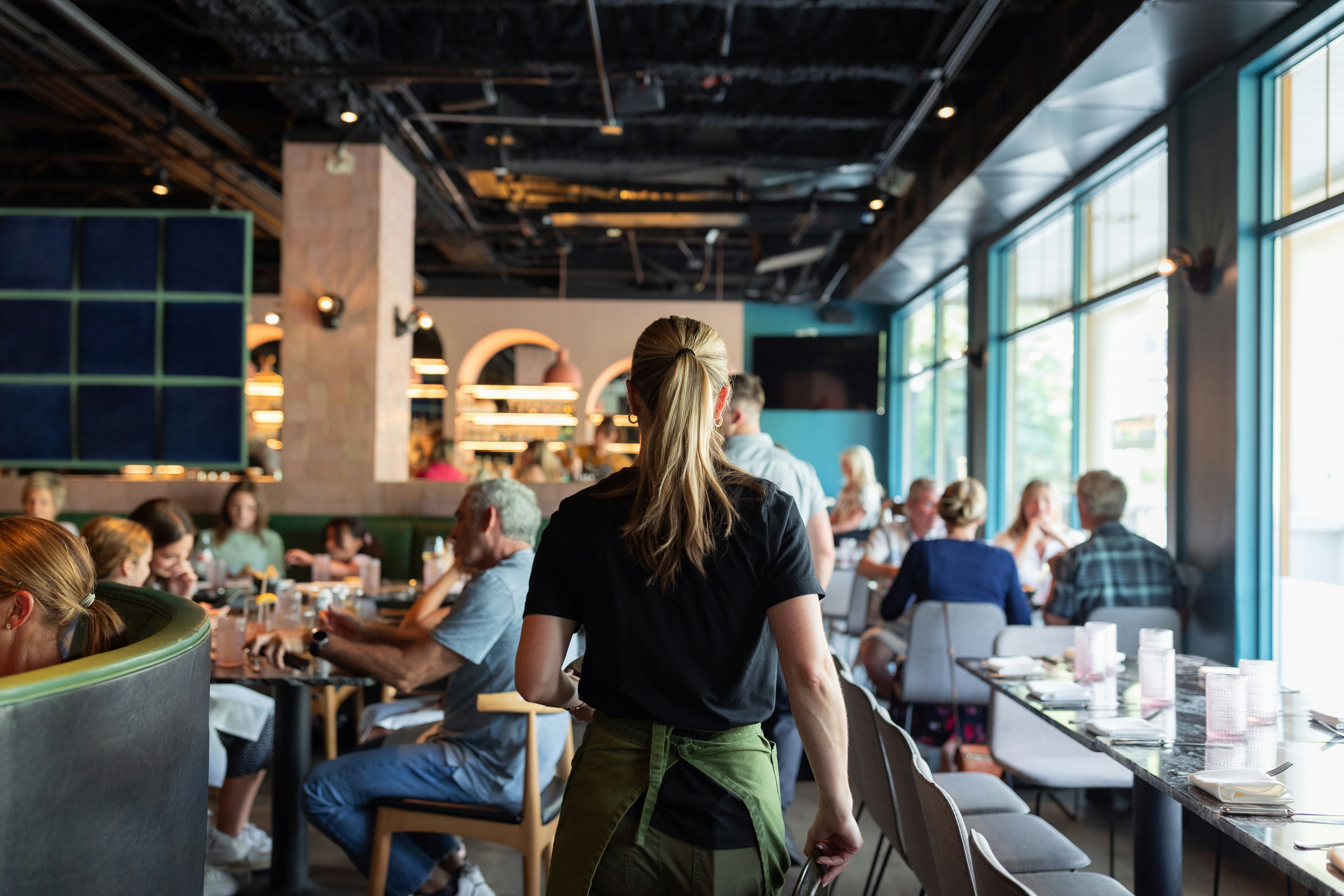 Busy restaurant dining room with servers and guests representing a franchise operation at full capacity