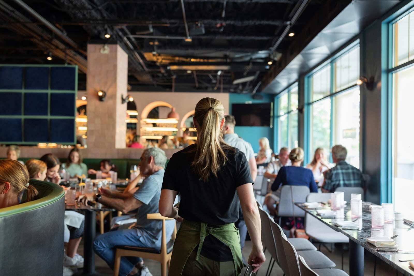 Busy restaurant dining room with servers and guests representing a franchise operation at full capacity